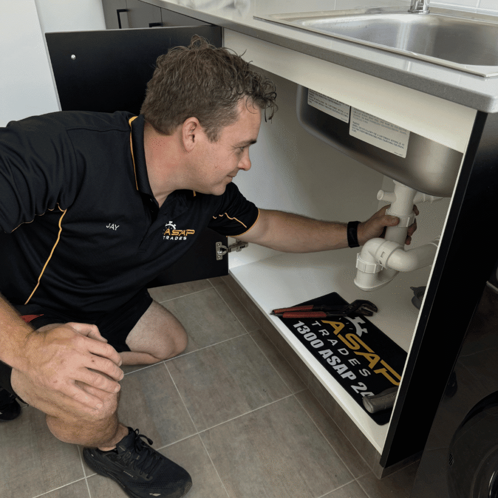 Photo of owner of asap trades working on under sink plumbing in Perth